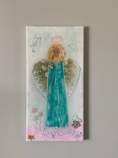 A canvas with glass arranged in the shape of an angel and sealed with resin.