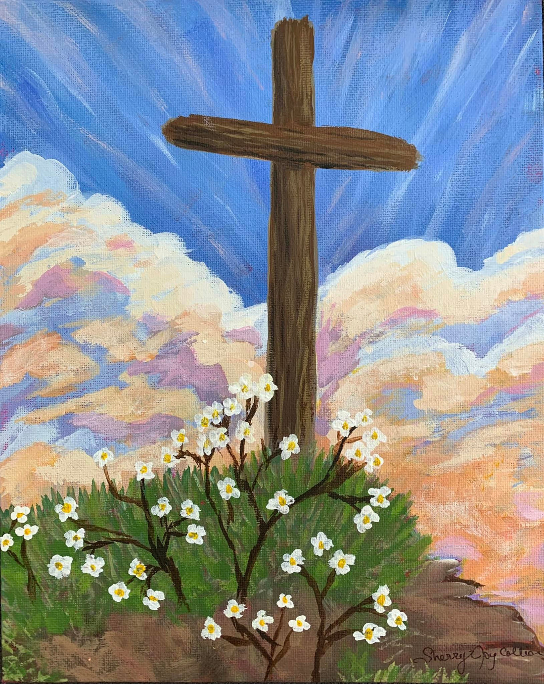 Hand painted cross on a hill with flowers with clouds and blue sky in the background.