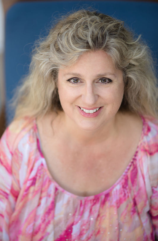 Photograph of Sherry smiling with a coral colored shirt.