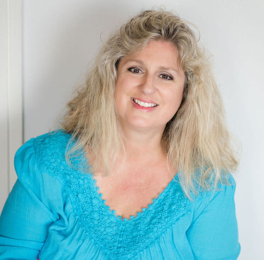 Photograph of Sherry smiling with a turquoise shirt.